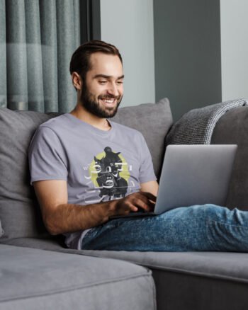 young-man-sitting-on-couch-wearing-organic-cotton-tshirt-crown&coo